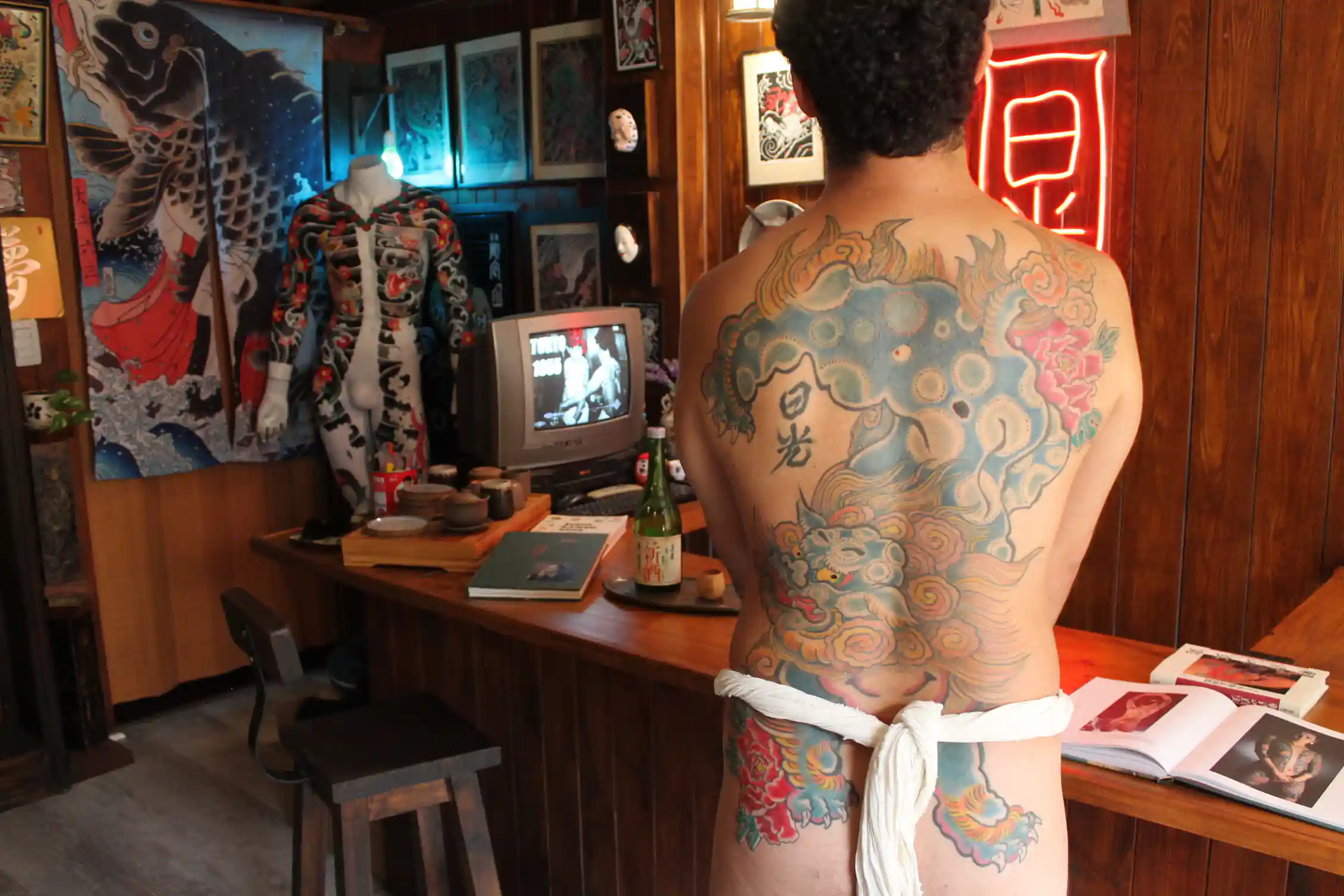 Tatuaje japonés de Karajishi y peonías en la espalda completa de Marcelo, realizado por Nikko Quiroga
