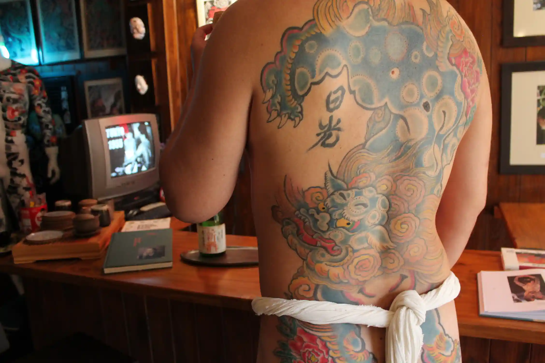 Detalle cercano del tatuaje de Karajishi en la espalda de Marcelo, con cría, melena y peonías