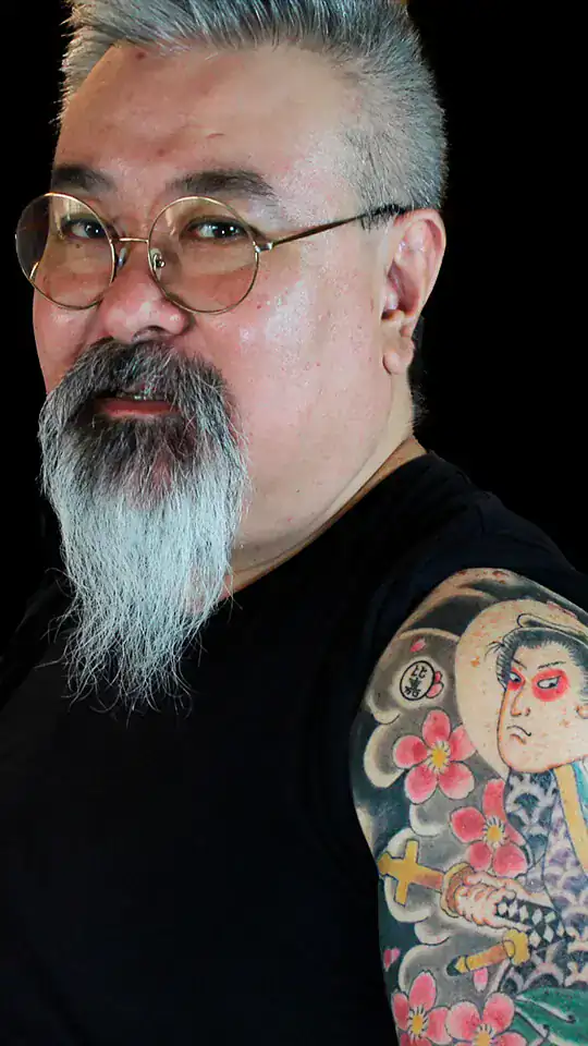 Tatuaje japonés del samurái cristiano Dom Justo Takayama, con sakura y fondo tradicional en nubes, realizado por Nikko Quiroga en manga de brazo.