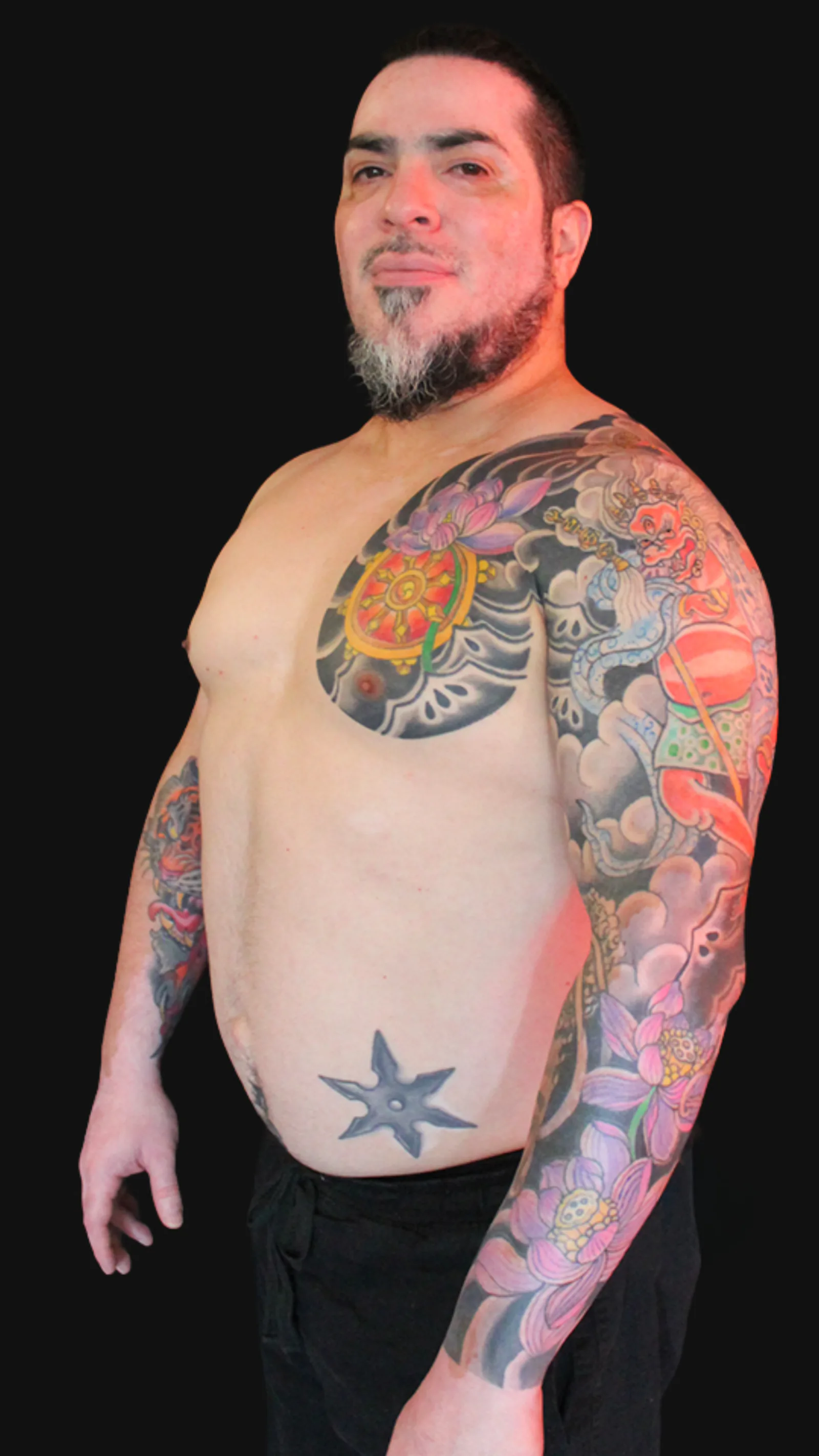 Tatuaje japonés de Makahala con la Rueda del Dharma y flores de loto, composición budista tradicional en manga completa, realizado por Nikko Quiroga en Olivos, Buenos Aires.